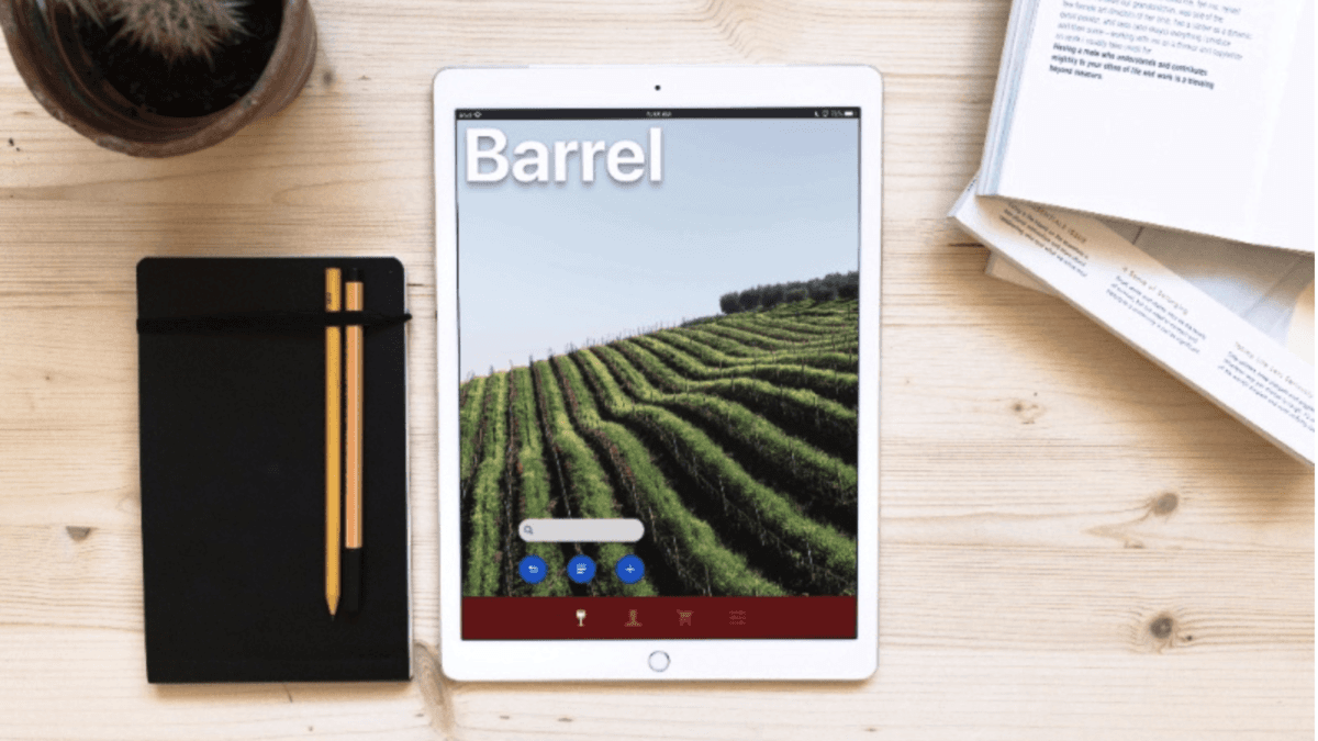 Desktop with books, notepads and iPad displaying login screen of Angel City Data's Barrel app.
