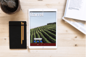 Desktop with books, notepads and iPad displaying login screen of Angel City Data's Barrel app.